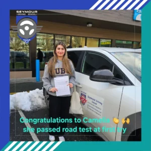 Camelia, wearing a grey UBC Engineering hoodie and black pants, smiles while holding a white form beside a white Seymour Driving School car under a caption saying she passed her road test on the first try.
